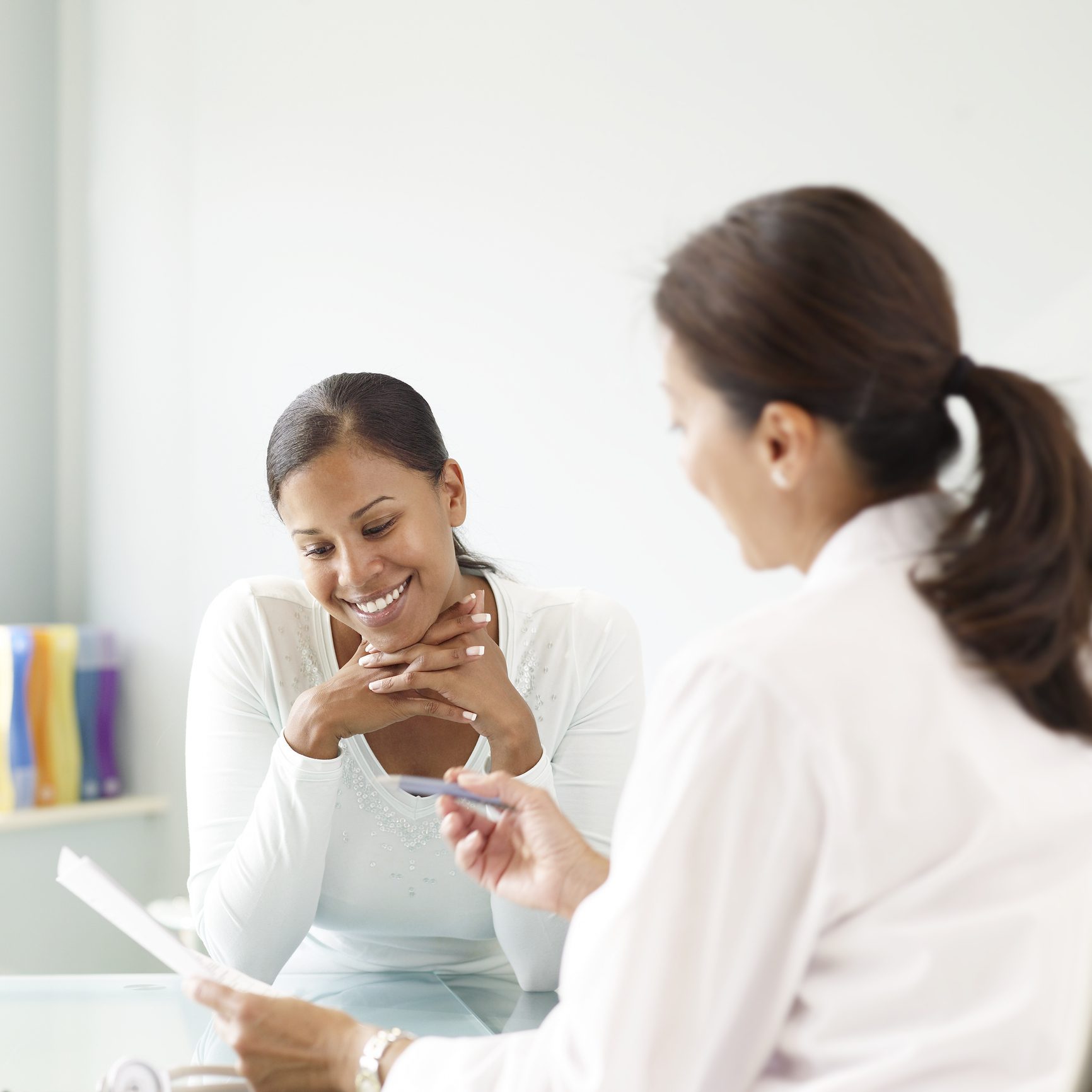 Young woman talking to doctor, smiling